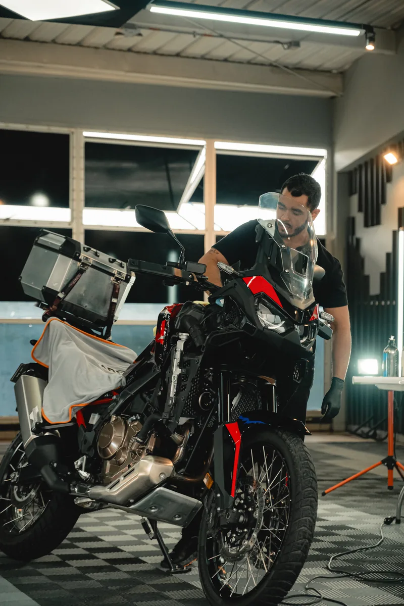 Técnico de Reflejauto junto a una moto en el taller de Manizales